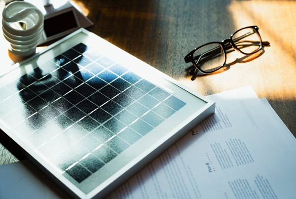 Photovoltaikmodul und Unterlagen zur Projektplanung auf einem Schreibtisch