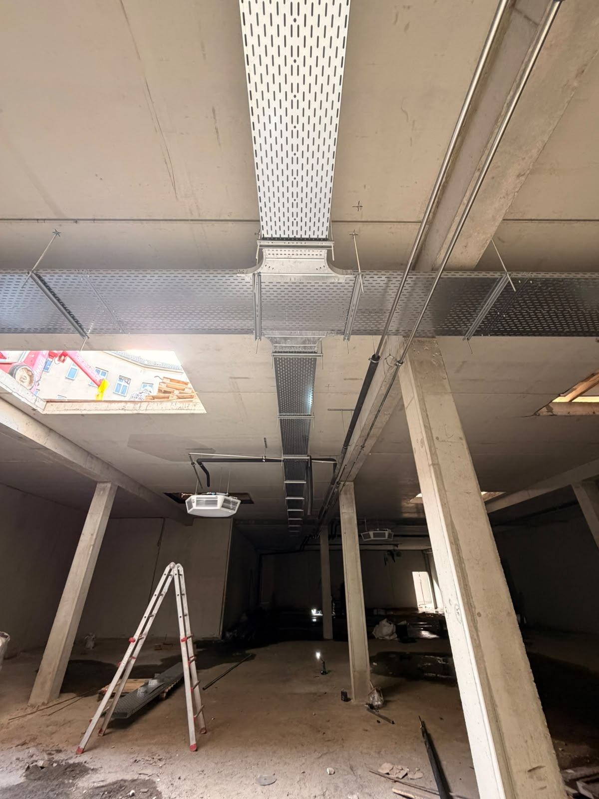Rohbauraum des Supermarkts mit Kabeltrassen und Deckenöffnungen