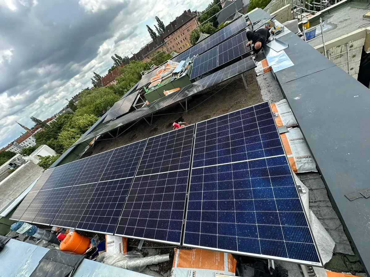 Aufgeständerte Modulreihen und Dachaufbauten während der PV-Montage