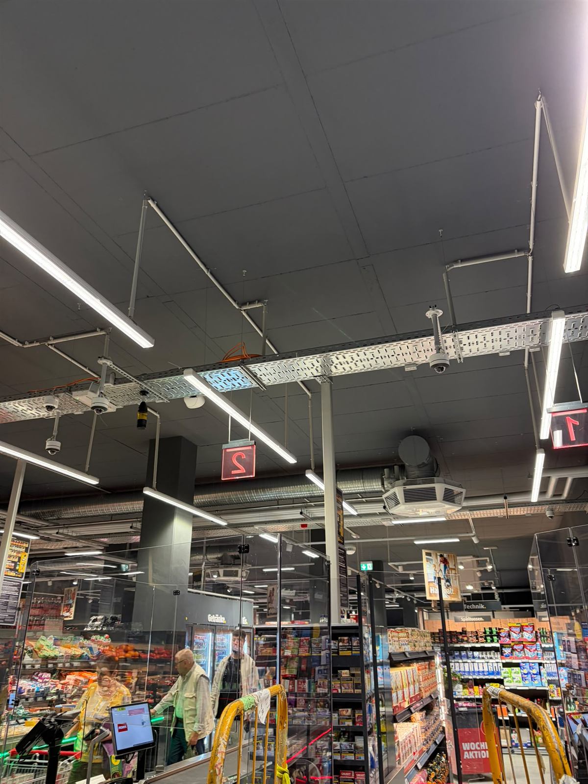 Verkaufsfläche mit Deckenleuchten und sichtbaren Kabeltrassen