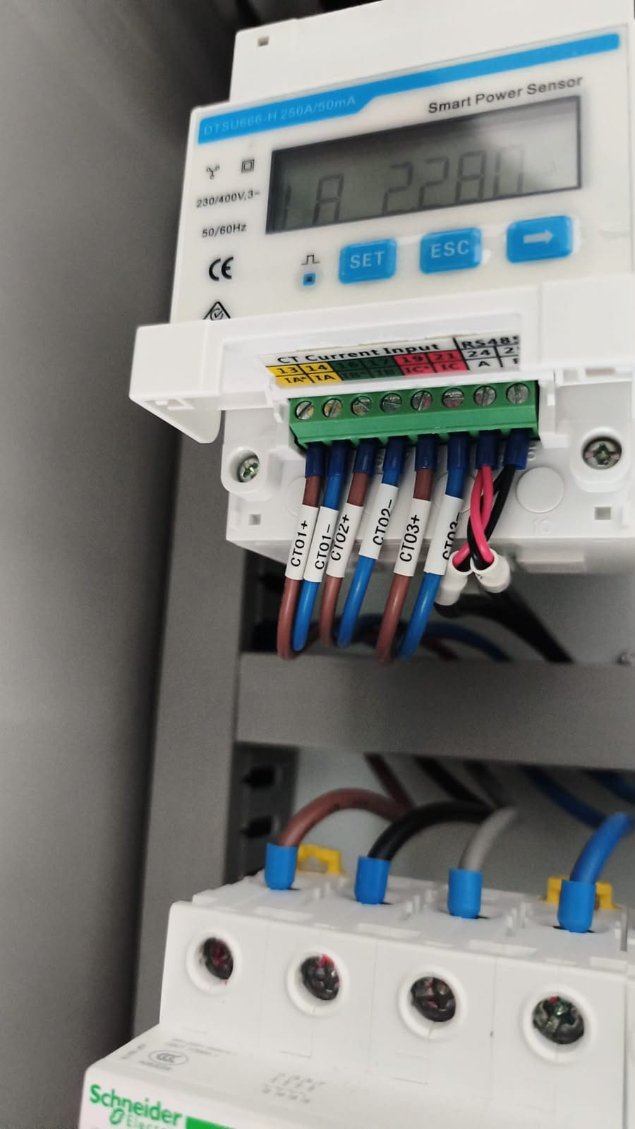 Digitaler Leistungssensor mit angeschlossenen Messleitungen im Schaltschrank